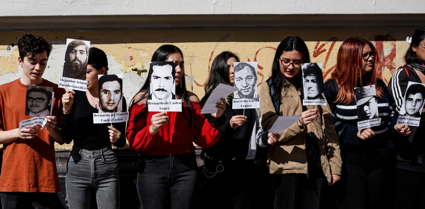 Students of the University of Chile stage a peaceful protest with pictures of missing people to mark International Day of the Victims of Enforced Disappearance, in Santiago on August 30, 2023, day in which Chile's President Gabriel Boric presented the National Search Plan for the Disappeared to find missing victims of the 1973-1990 dictatorship.