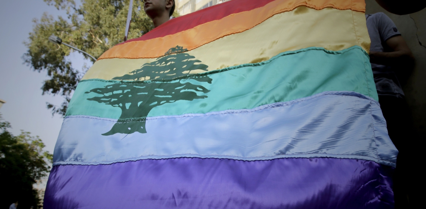 A gay pride flag bearing the cedar tree in the middle of it is carried by human rights activists during an anti-homophobia rally in Beirut on April 30, 2013. Lebanese homosexuals, human rights activists and members from the NGO Helem (the Arabic acronym of "Lebanese Protection for Lesbians, Gays, Bisexuals and Transgenders") rallied to condemn the arrest on the weekend of three gay men and one transgender civilian in the town of Dekwaneh east of Beirut at a nightclub who were allegedly verbally and sexually harassed at the municipality headquarters. AFP PHOTO/JOSEPH EID (Photo by Joseph EID / AFP) (Photo by JOSEPH EID/AFP via Getty Images)
