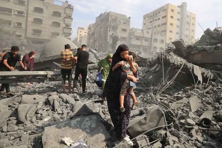 Des Palestiniens et Palestiniennes évacuent une zone suite à une frappe aérienne israélienne sur la mosquée Sousi dans la ville de Gaza, le 9 octobre 2023.