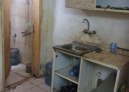 La imagen muestra módulos de lavabo y baño sucios y deteriorados en alojamientos para trabajadores de Al-Mutairi