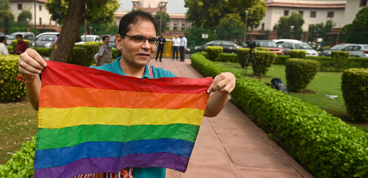 A member of the LGBTQ community holds a rainbow flag at the courtyard of the Supreme Court of India, during the judgement on same-sex marriage by Supreme Court in New Delhi, India on October 17, 2023. India's top court said on Tuesday that it cannot legalise same-sex marriages.
