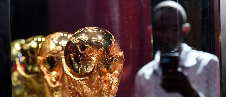 An image if the men's World Cup trophy reflected in a glass cabinet