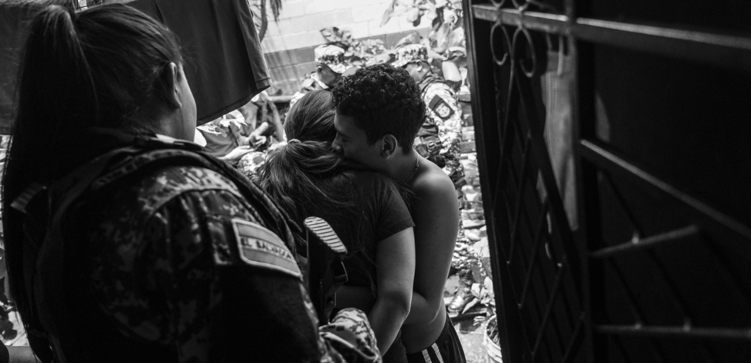 A suspect hugs her son while being escorted by police in a house by house operative while searching for an alleged gang member on July 6, 2022 in Soyapango, El Salvador