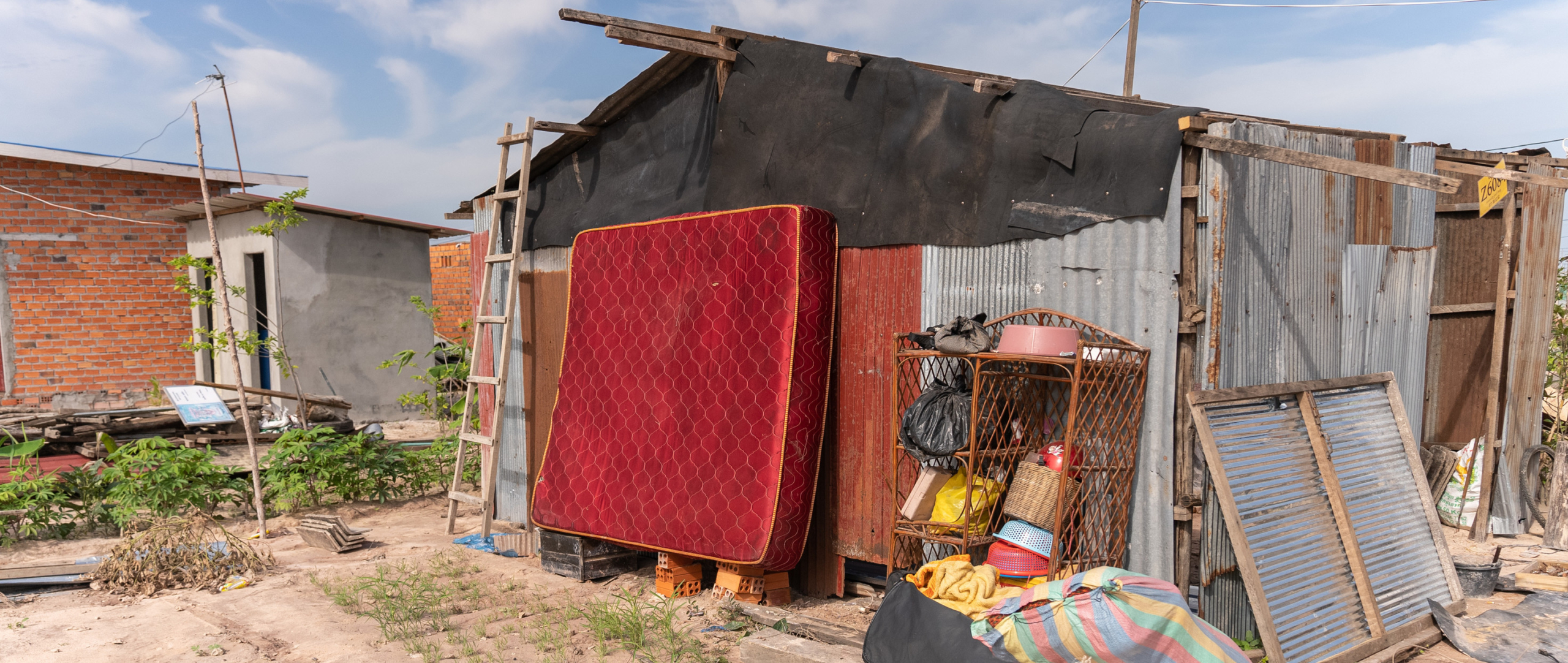 In this image taken in July 2023, residents’ belongings are seen drying in the sun after a violent storm and flood that happened the week before this image was taken at the Run Ta Ek resettlement site in Siem Reap, Cambodia.