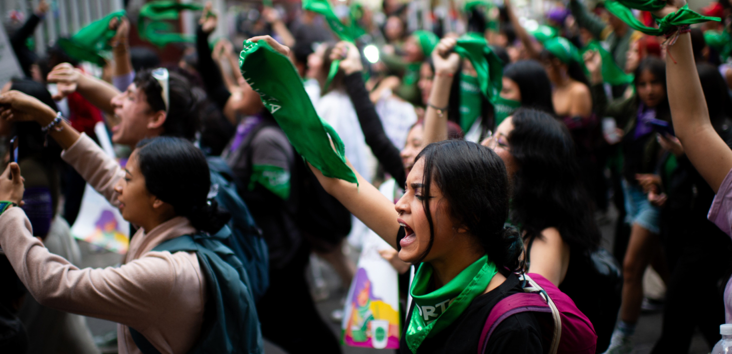 People hold up green flags in Colombia in solidarity for women's right to abortion