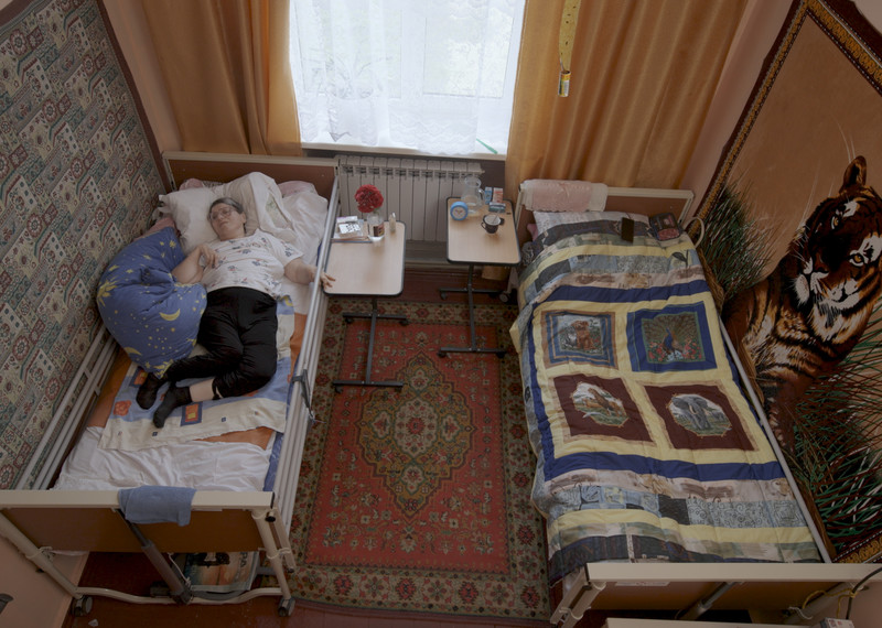 Жінка з церебральним паралічем лежить у ліжку. 