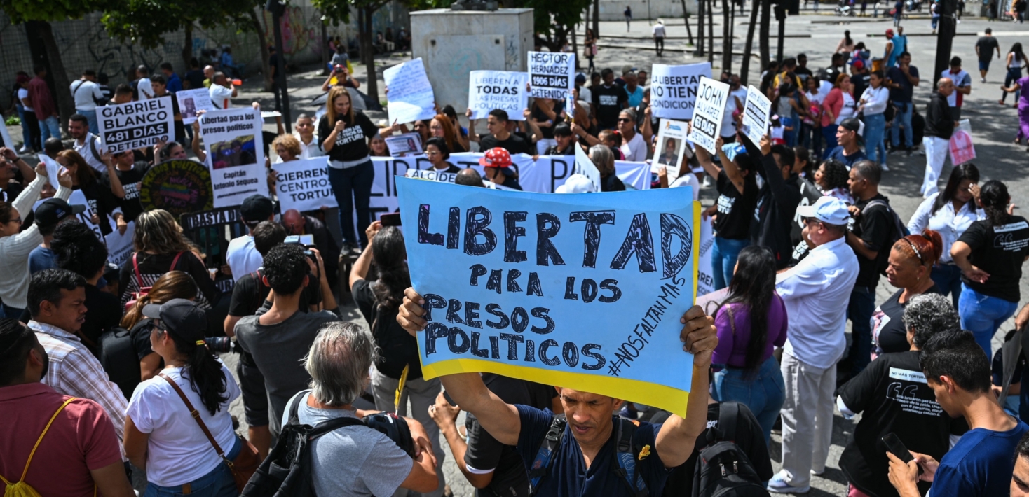A man holds a sign that reads "Freedom for the political prisoners" during a demonstration to demand their release in Caracas on November 1, 2023.