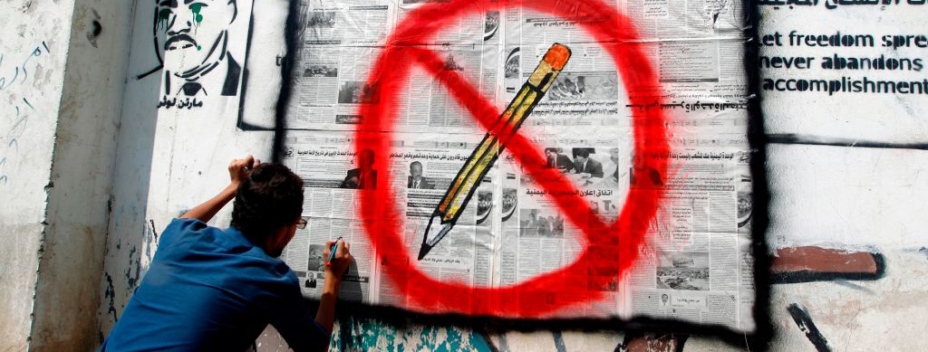 A Yemeni artist sprays graffiti on a wall in the capital Sanaa criticising the limitations on the freedom of press in Yemen on September 19, 2016.