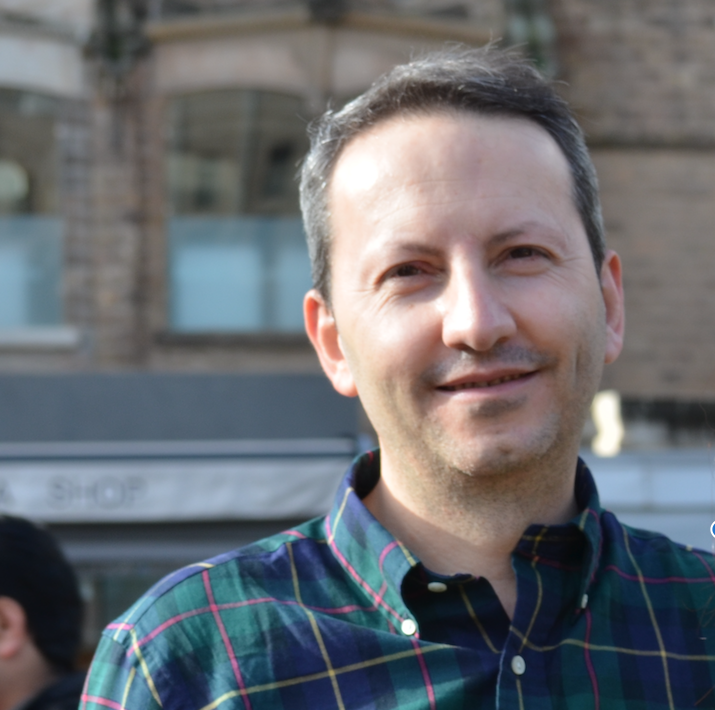 undated photo of Ahmadreza Djalali, Swedish-Iranian dual national posing for a photo wearing a striped green shirt and smiling.