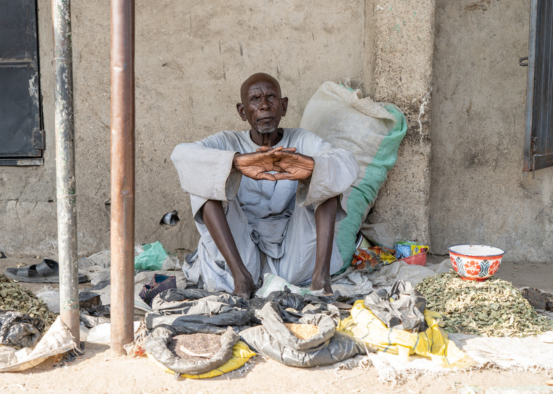 On older man sits and waits to sell food at a market near Maiduguri, Borno State, northeastern Nigeria.