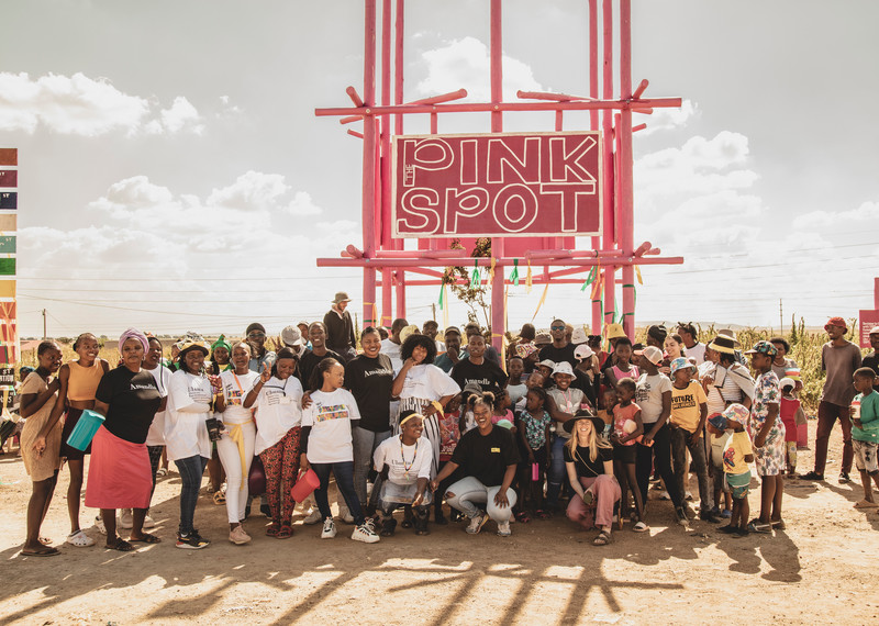 Un grupo de jóvenes activistas frente a una construcción en forma de torre, denominada The Pink Spot (el punto rosa)