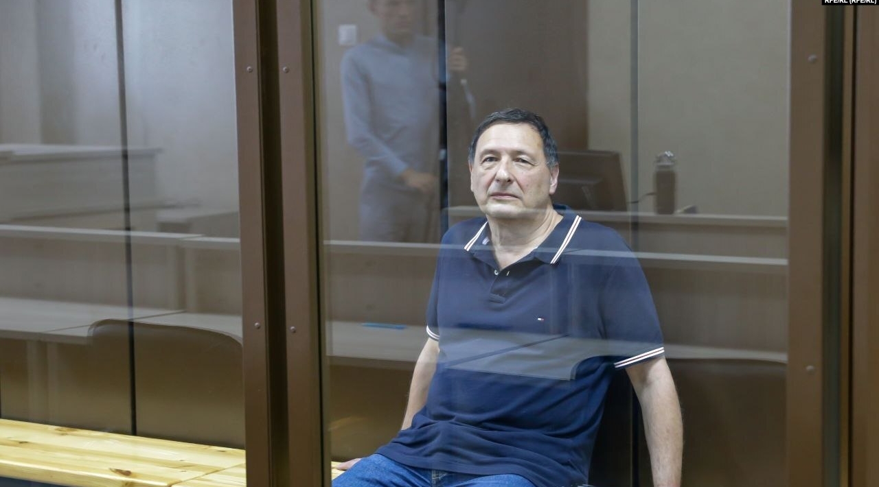 Boris Kagarlitsky sitting in a glass cage in the court room