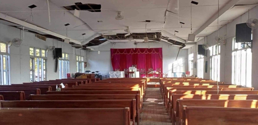 Interior dañado de la iglesia de San Pedro Bautista, con las lámparas del techo desprendidas tras los ataques.