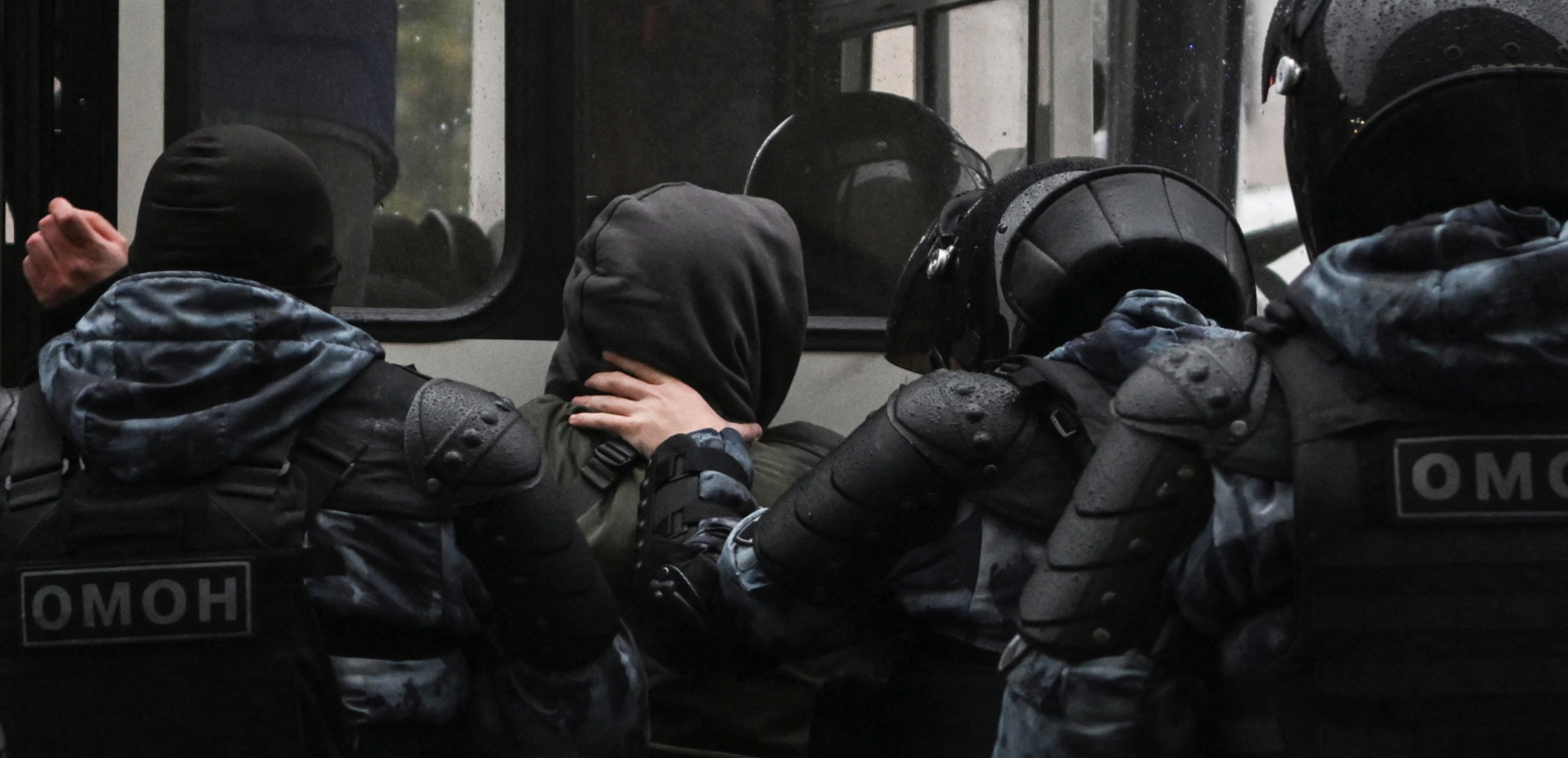 Police officers detain a man in Moscow on September 24, 2022, following calls to protest against the partial mobilisation announced by the Russian President