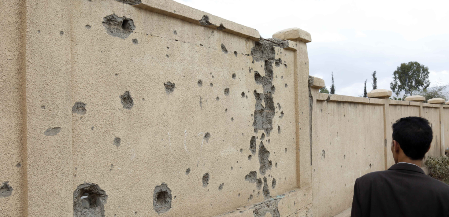 A man looks at a wall with monuments of a building destroyed in past aerial strikes carried out by warplanes from a coalition led by Saudi Arabia, as Yemen marks its war's 8th anniversary, on March 28, 2023 in Sana'a, Yemen.