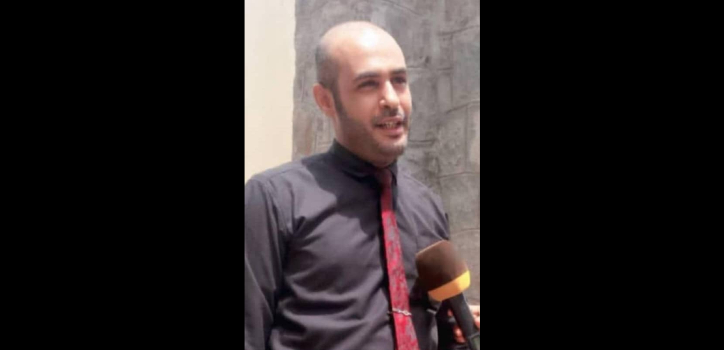 Yemeni human rights lawyer Sami Yassin Ka’id Marsh, who has been arbitrarily detained without charge for four months, is seen in an undated photo speaking in an interview, wearing dark shirt and red necktie.