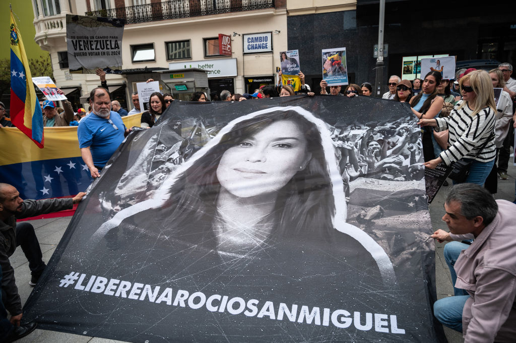 People hold a large banner with the face of Rocío San Miguel, lawyer and human rights activist, during a rally under the slogan "against the electoral blockade and the violation of human rights in Venezuela