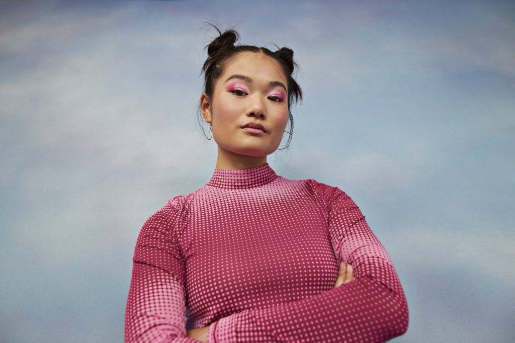 Girl with arms crossed against colored background