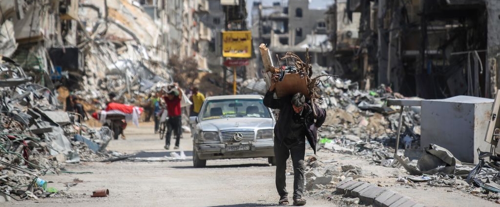 A man carries items on his back as people remove possessions from their homes following Israeli airstrikes on April 13, 2024 in Khan Yunis, Gaza. The Israeli military has scaled back ground troops in the southern Gaza Strip, leaving only one brigade. However Israeli officials have vowed to launch a ground invasion of Rafah at a later date.
