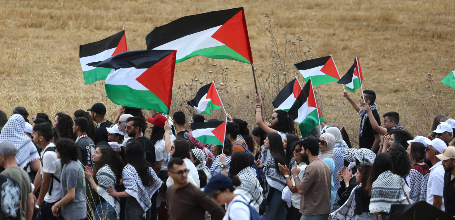 Palestinian protesters wave flags during a rally near Israel's northern city of Shefa Amr, on May 14, 2024, ahead of the Palestinian marking of the 76th anniversary of the Nakba,