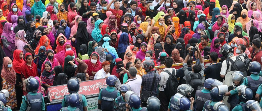 Hundreds of female garment workers in Dhaka, Bangladesh, demanding increase of their minimum wage, being confronted by the police in riot gear.