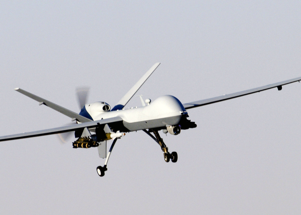 a MQ-9 reaper, an unmanned plane, in flight. the design is thin, lean and windowless. 
