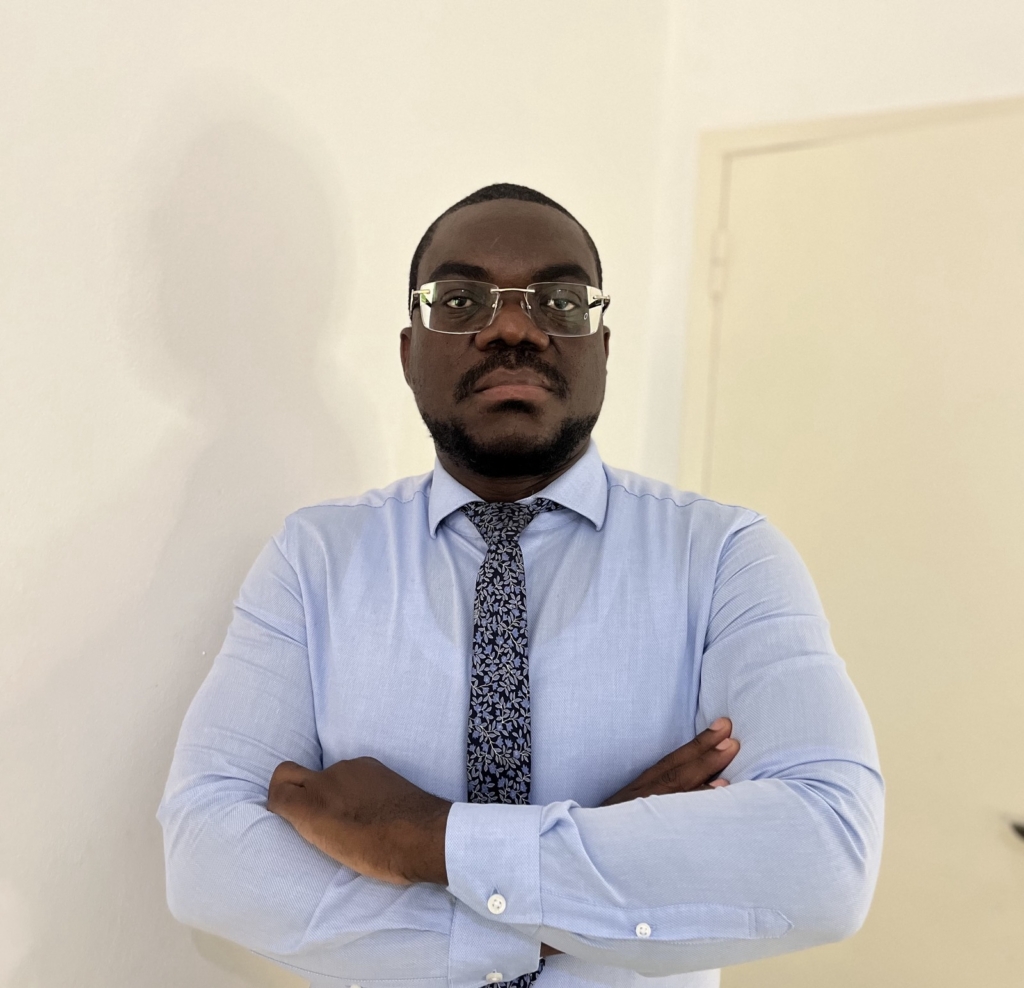 El destacado periodista, jurista y activista en favor de la libertad de prensa angoleño Teixeira Cândido posa para la cámara con una camisa azul y una corbata negra.