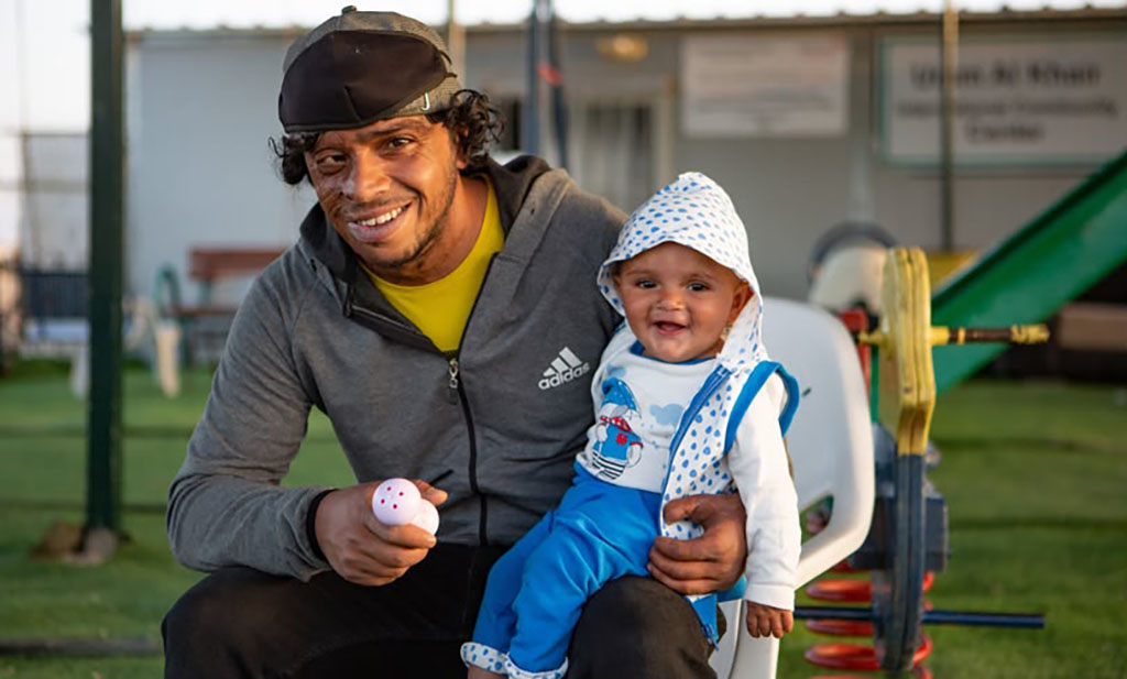 A man holds a child on his lap