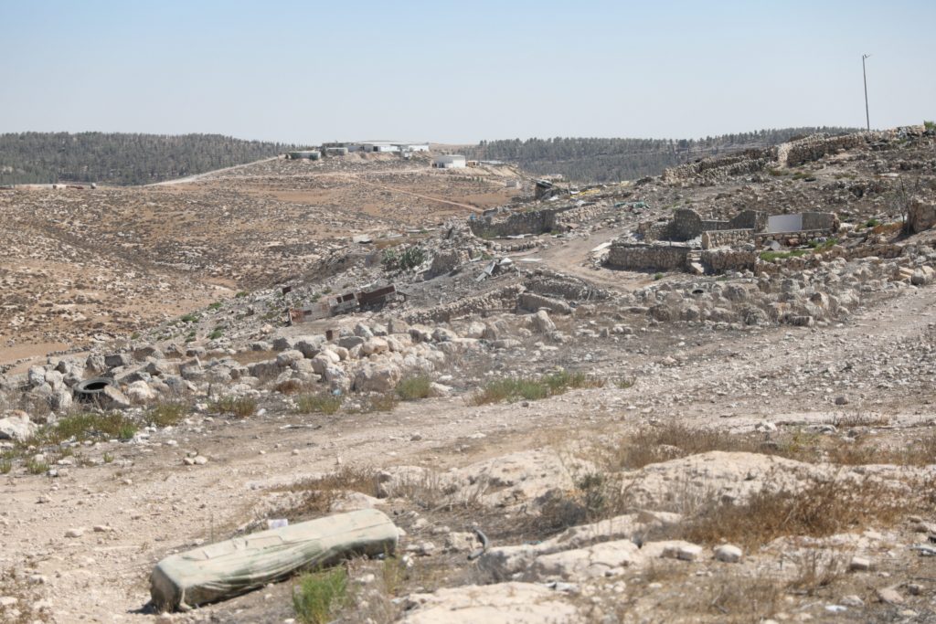 Ruins in Zanuta following the village’s destruction by settlers. Meitarim Farm is pictured in the background, on the overlooking hill. 1 September 2025.