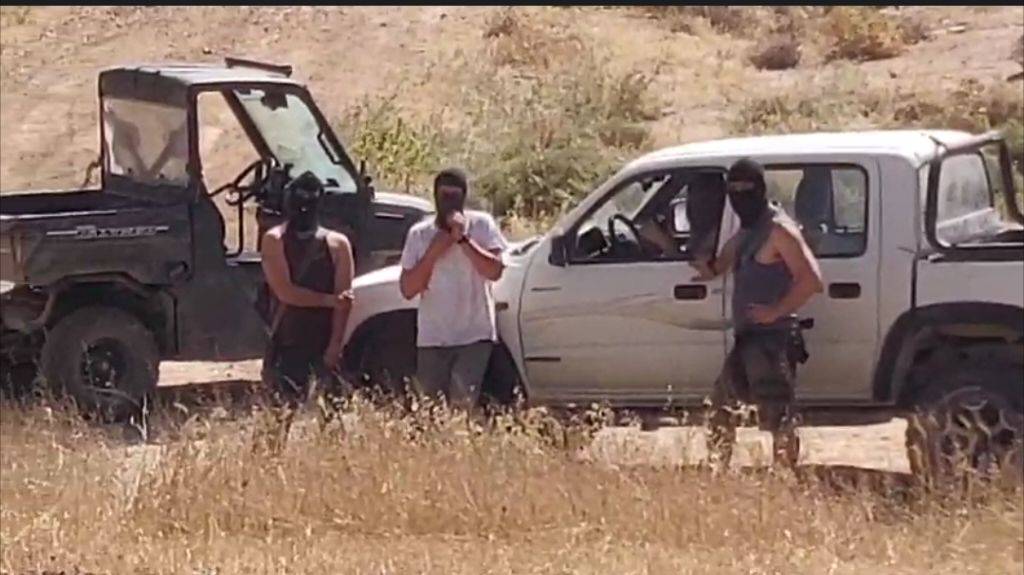 Four men wearing balaclavas
