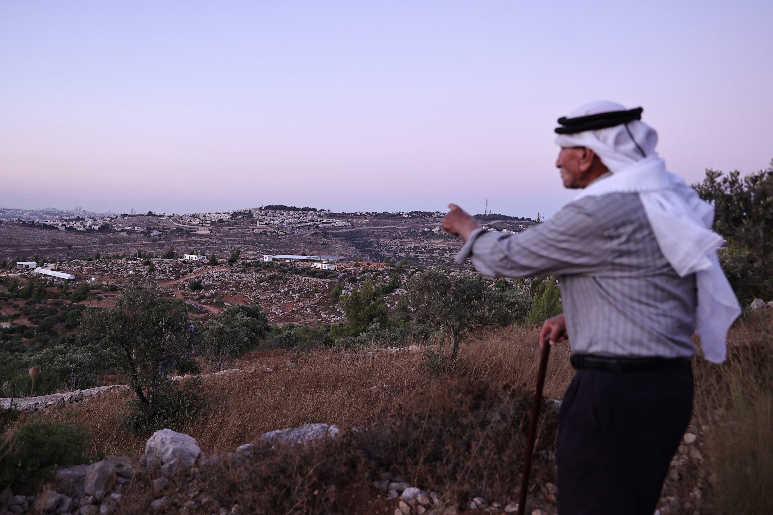 A palestinian man overlooking hills