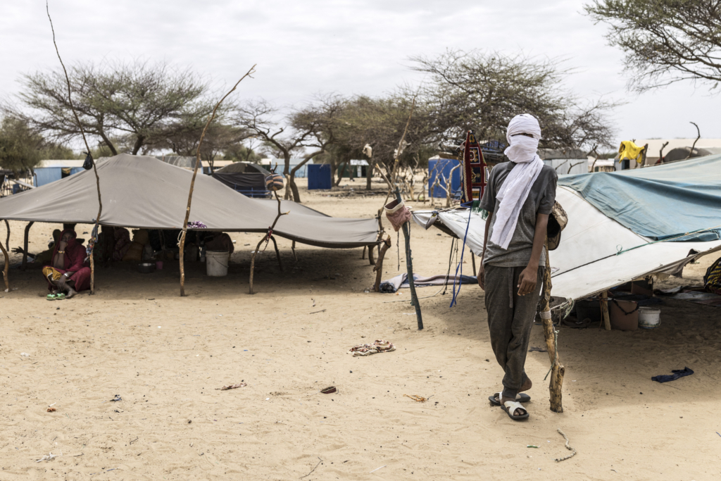 A refugee stands next to a tent at a makeshift camp in Doueinkara, near the Mauritanian border with Mali.