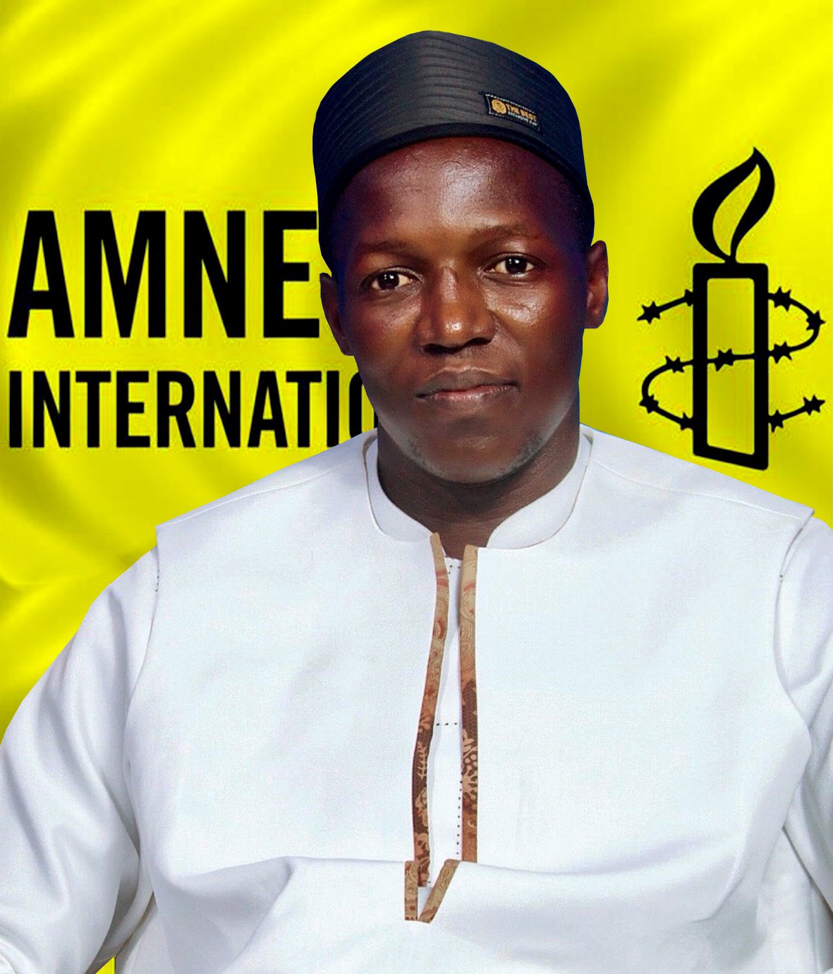 Peter Diene Fa'afui in front of an Amnesty international yellow background with the amnesty logo. He is wearing a white collared shirt and a black hat 