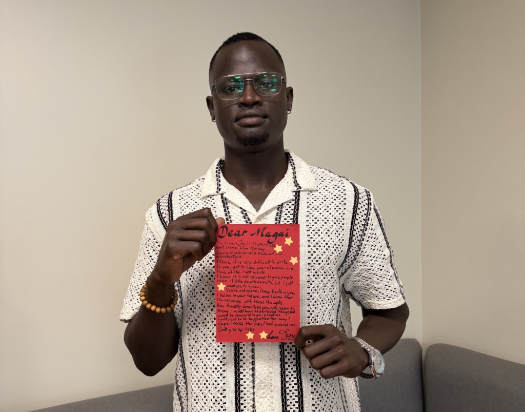 A man stands holding a red letter
