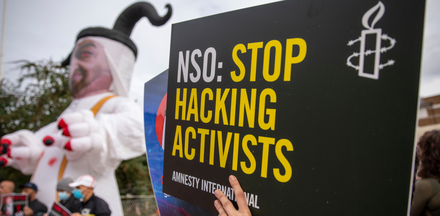 Activistas sostienen un cartel que dice “dejen de hackear a activistas”.