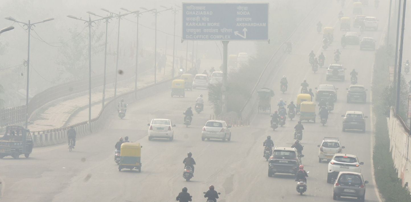 Vía de alta circulación cubierta de niebla urbana en Delhi.