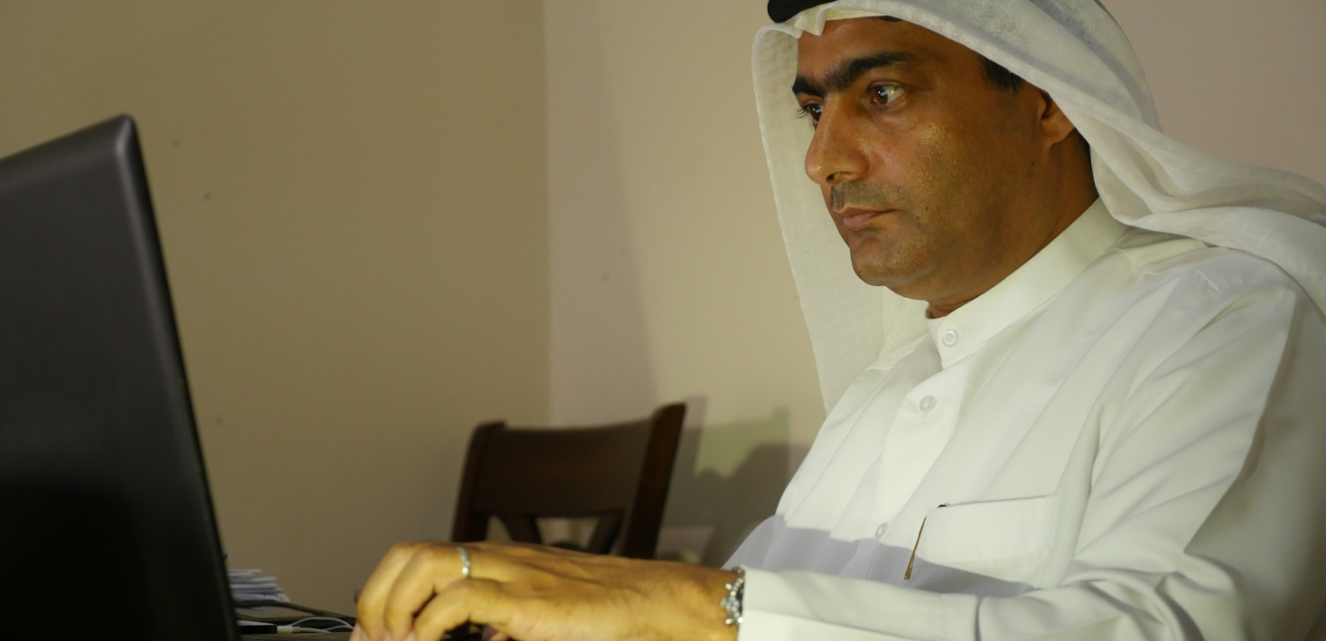 Fotografía sin fechar que muestra a Ahmed Mansoor, ataviado con el traje blanco tradicional de los EAU, sentado ante su ordenador portátil.