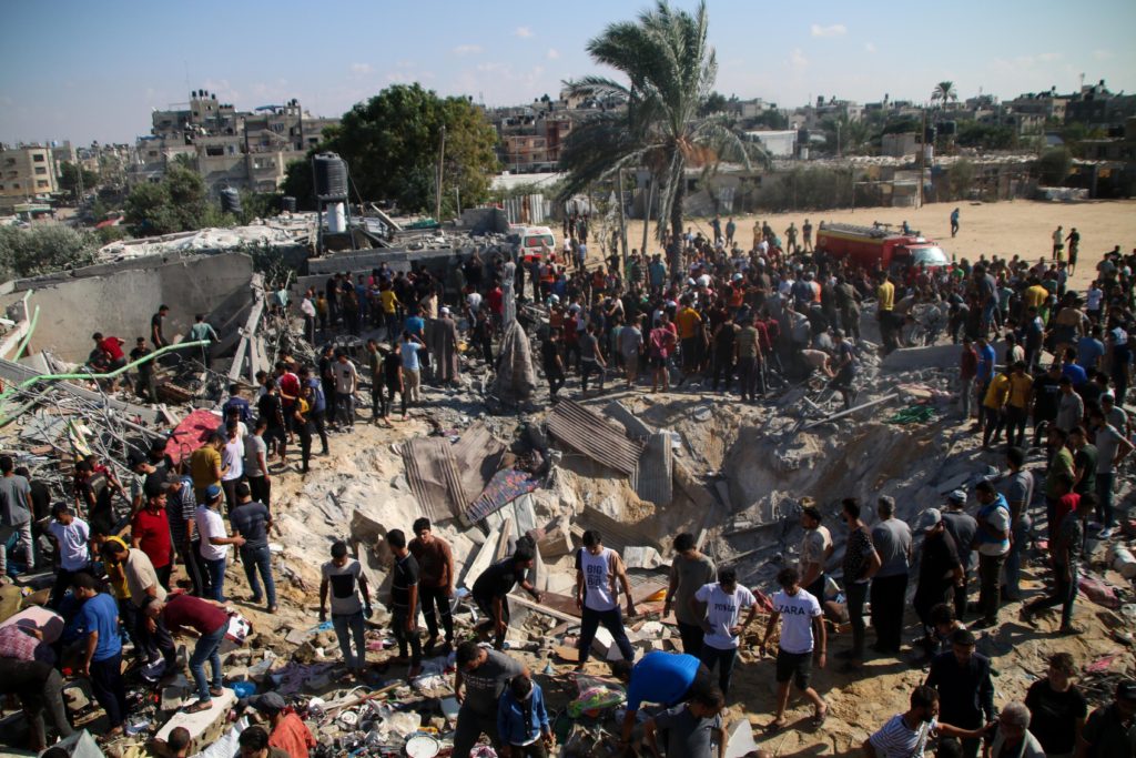 Servicios de emergencia palestinos y residentes de la zona buscan víctimas entre los escombros de los edificios destruidos durante los ataques aéreos israelíes en el sur de la Franja de Gaza el 19 de octubre de 2023 en Jan Yunis, Gaza. Gazatíes en proceso de evacuación hacia el sur siguiendo la recomendación del gobierno israelí antes de una ofensiva terrestre planeada de Israel.