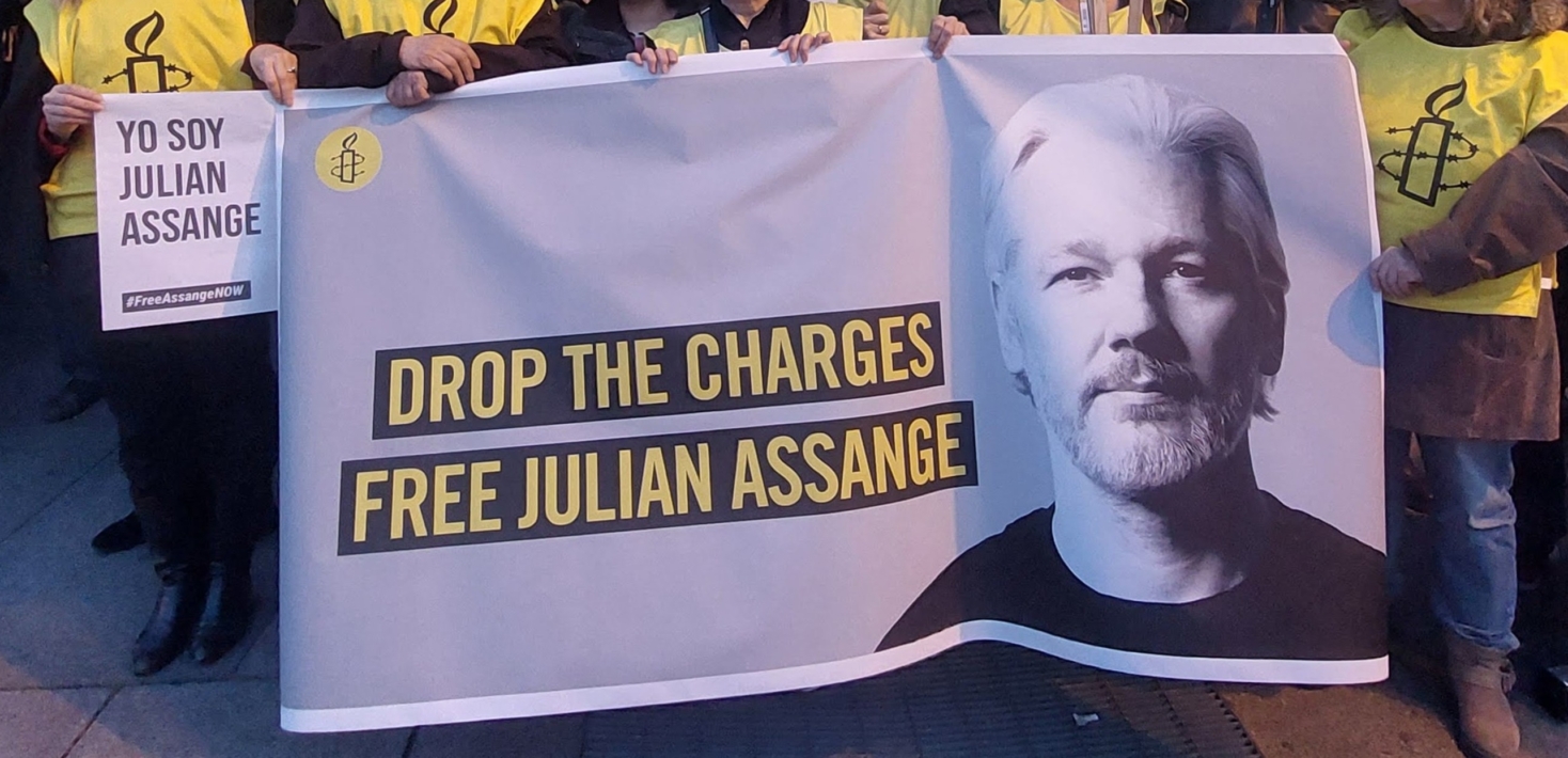 Manifestantes con una pancarta que dice “Retiren los cargos. Liberen a Julian Assange”.