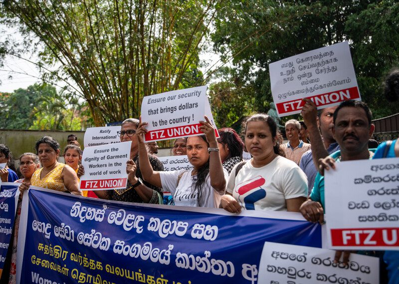 Fila de personas con pancartas en un acto de protesta.