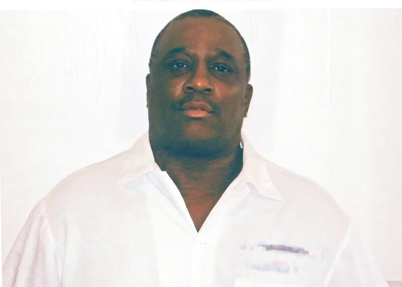 Rocky, vestido con camisa blanca, mirando al frente, contra un fondo blanco.