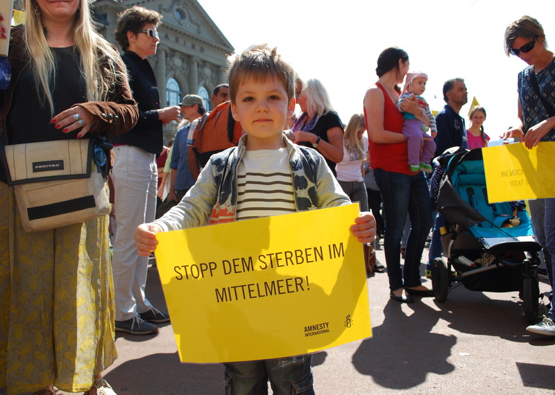 Un niño muestra solidaridad con las personas refugiadas en una manifestación en Berna, Suiza, septiembre de 2015. © Amnesty International