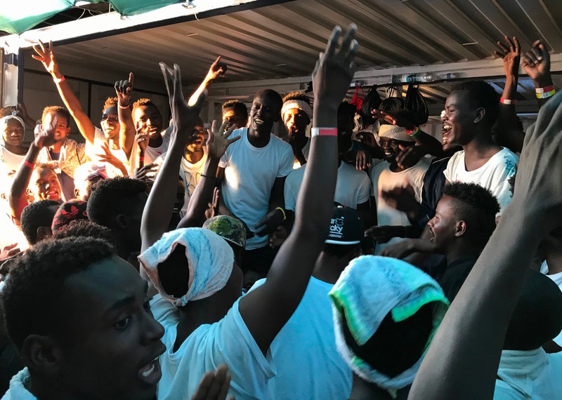 Alegría de las personas migrantes rescatadas en la cubierta del buque de salvamento Ocean Viking. © Anne Chaon/AFP/Getty Images