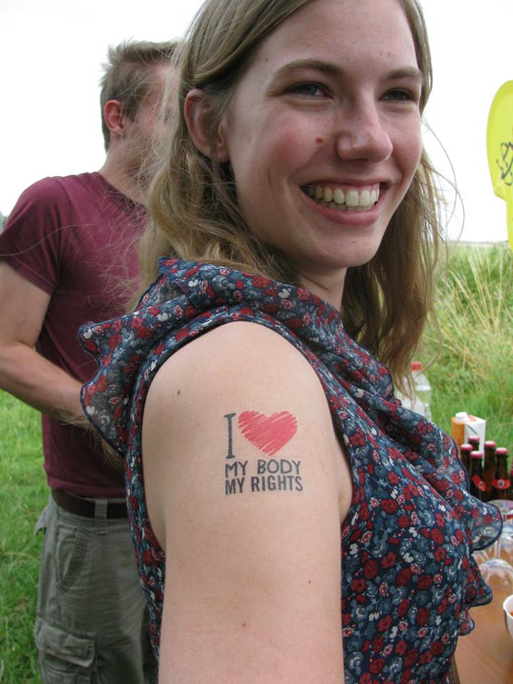 Una joven activista muestra su tatuaje de la campaña Mi Cuerpo, Mis Derechos para incitar a que la gente firme la petición para “frenar las violaciones en Bélgica”, Oostende julio de 2014. © Amnistía Internacional