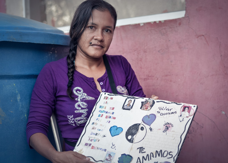 Nereida muestra un póster dibujado por sus hijos dedicado a su padre Oliver. Él es uno de los migrantes que aún continúan desaparecidos.