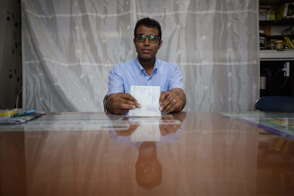 Mohammed Salem Duhaish, yemení solicitante de asilo de 33 años, muestra su visado surcoreano sentado en las oficinas de la ONG Red por los Derechos de las Personas Refugiadas de Jeju.  ED JONES/AFP/Getty Images