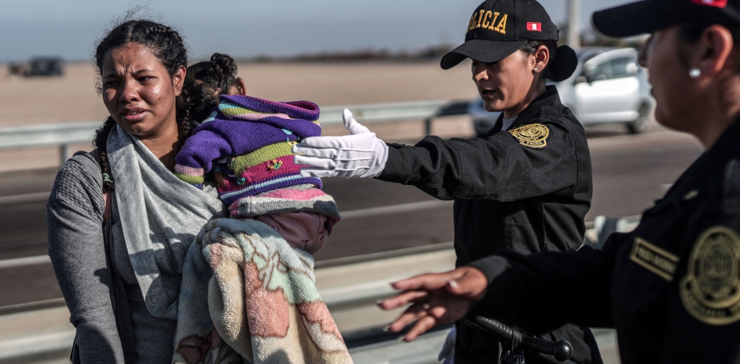 A migrant woman is escorted by Peruvian police officers to a migration office in Tacna, in the Peru-Chile border on April 28, 2023