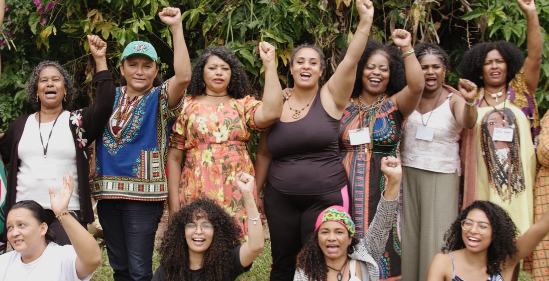 Women from the Brazilian activist group Rede Vozes Negras pelo Clima raise their fists