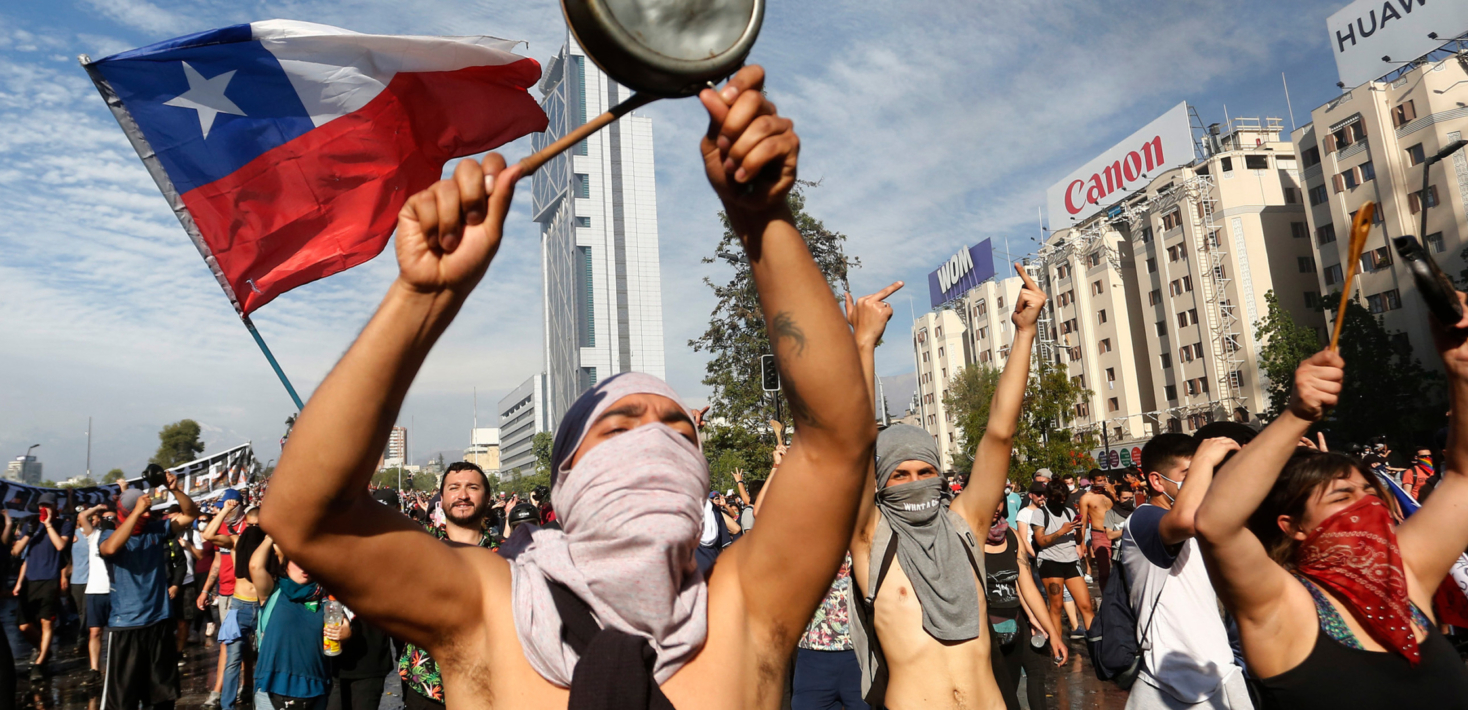 Demonstrators display flags and banners during a protest against President Sebastian Piñera on October 21, 2019 in Santiago, Chile.