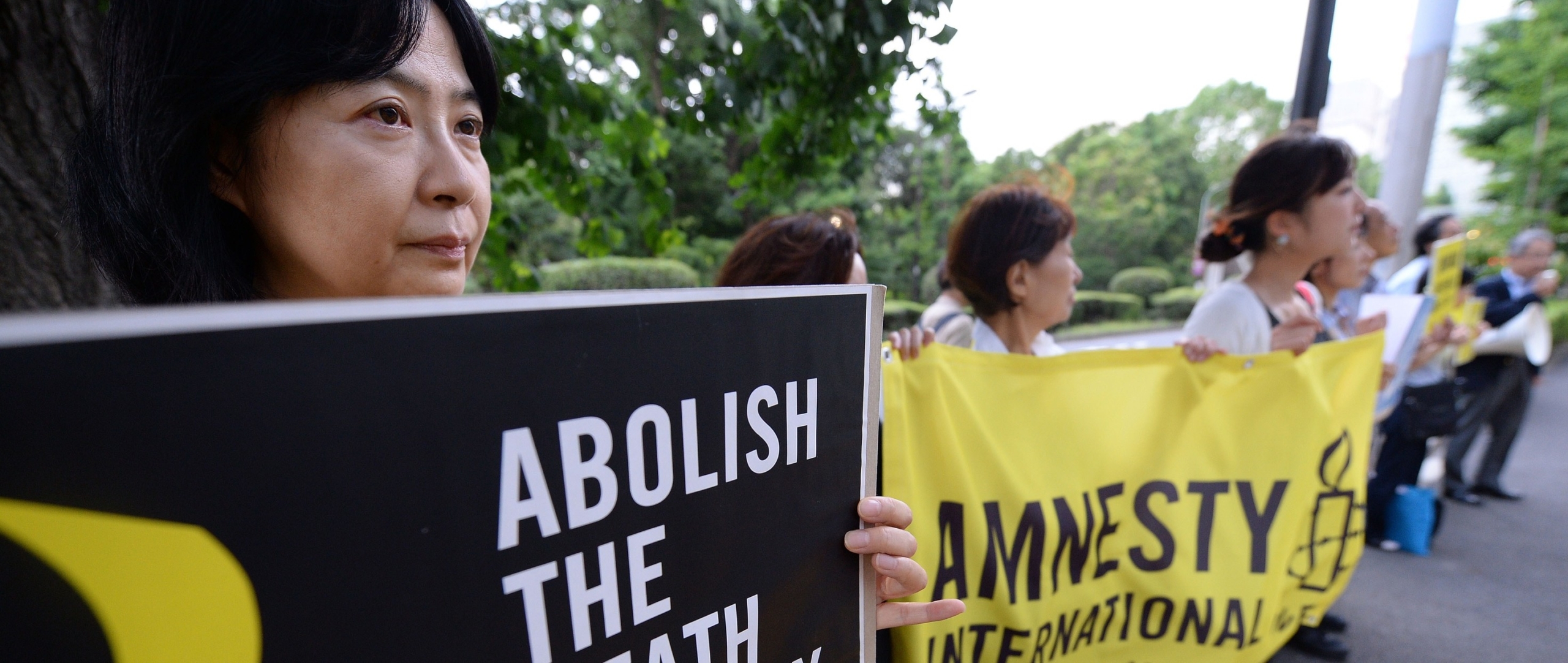 Des membres d'AMnesty tiennent des pancartes appelant l'abolition de la peine de mort
